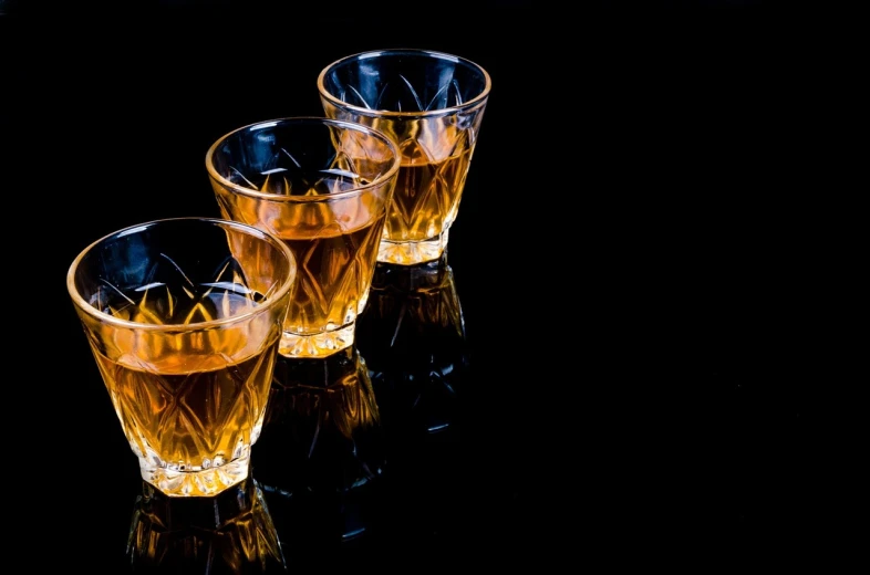 a couple of glasses sitting on top of a table, inspired by William Grant Stevenson, dau-al-set, on black background, hdr refractions, in a row, drinking whiskey