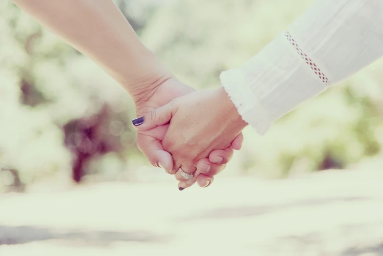 a close up of two people holding hands, a picture, by Elsa Bleda, shutterstock, romanticism, retro effect, two beautiful women in love, holding a stuff, no dof