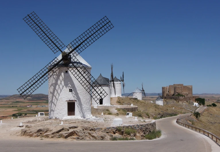 a couple of windmills sitting on top of a hill, inspired by Pedro Álvarez Castelló, flickr, baroque, white buildings, the three moiras, diego velazquez, from wikipedia