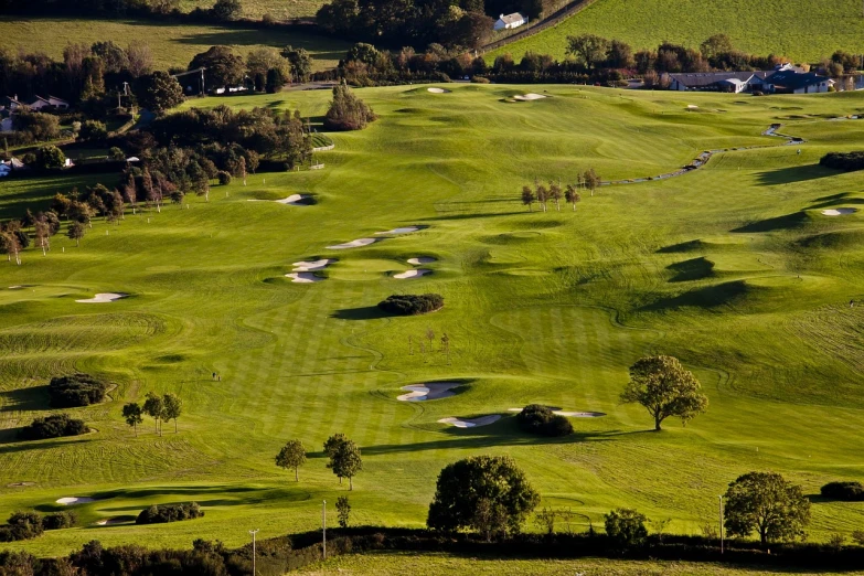 a view of a golf course from the top of a hill, by John Hutton, flickr, cornwall, very elegant & complex, morning lighting, holes