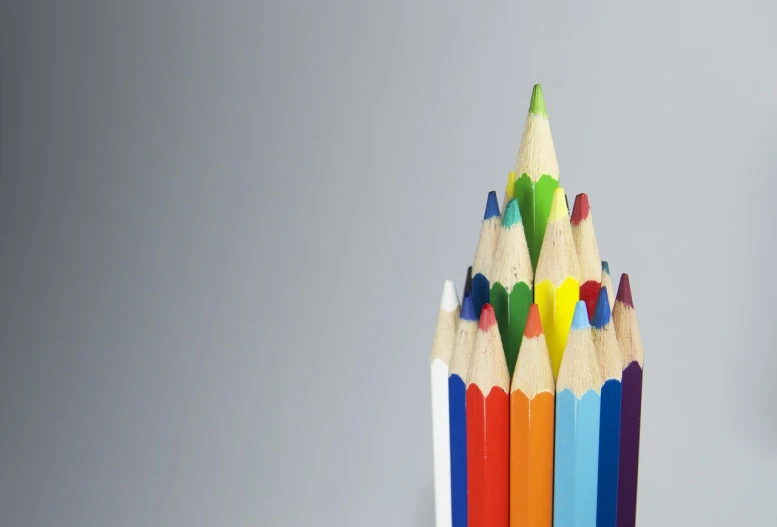 a group of colored pencils sitting on top of each other, a color pencil sketch, crayon art, product introduction photo, on grey background, stock photo