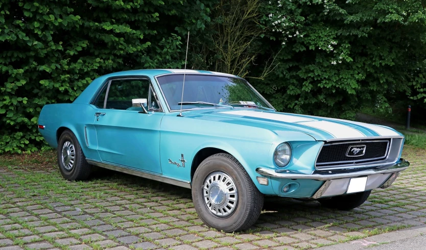 a blue mustang parked on a cobblestone road, a pastel, by Arnie Swekel, pixabay, brown and cyan color scheme, year 1968, stock photo, aerodynamic body