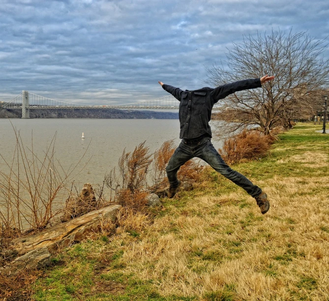 a person jumping in the air near a body of water, by David Palumbo, humans of new york, hdr photo, happy friend, river in front of him