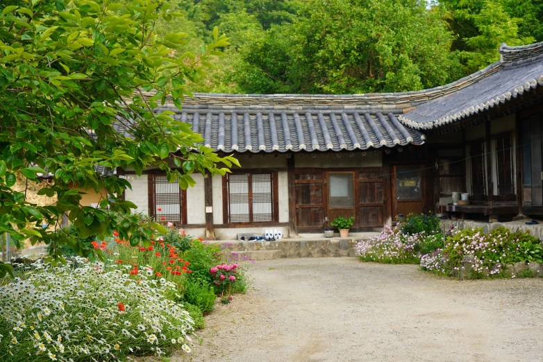 a couple of houses that are next to each other, a picture, inspired by Kim Hong-do, flickr, ancient garden behind her, korean countryside, exterior photo, ecovillage