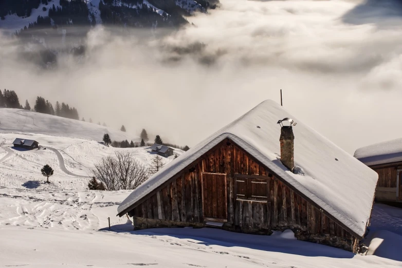 a cabin sitting on top of a snow covered slope, by Franz Hegi, shutterstock, smoke and clouds, barn in the background, stock photo, switzerland