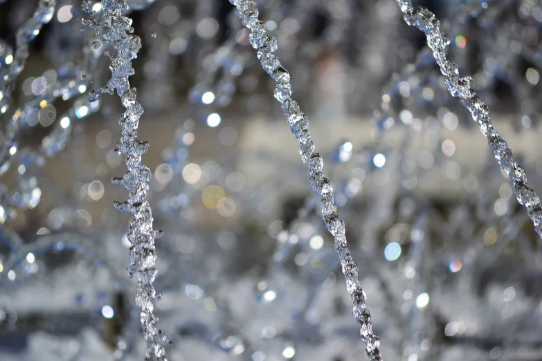 a close up of water spouting from a fountain, a microscopic photo, inspired by Arthur Burdett Frost, pexels, crystal cubism, glittering silver ornaments, draped with water and spines, high quality image”, wintertime