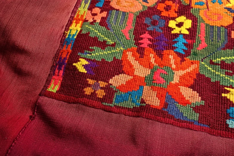 a close up of a rug with flowers on it, a cross stitch, by Virginia Lee Burton, instagram, qajar art, double layer fold over hem, mexico, deep colours. ”, over the shoulder closeup