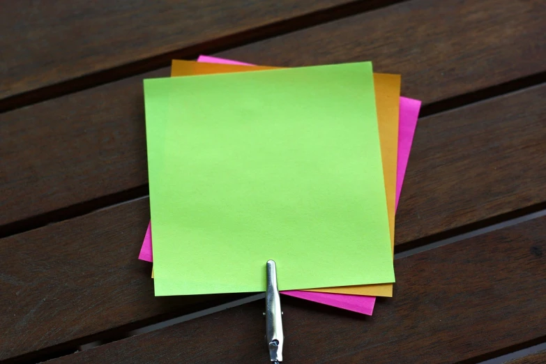 a pair of scissors sitting on top of a piece of paper, synchromism, outdoor photo, colorful ideas, green colors, ink on post it note