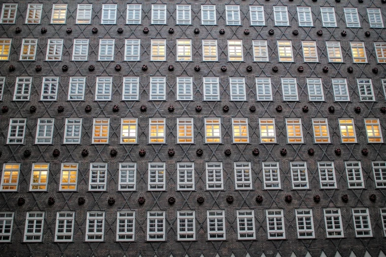 a very tall building with lots of windows, inspired by Matthias Jung, berlin secession, window. netherlands tavern, dark grey and orange colours, beautiful texture, rows of windows lit internally