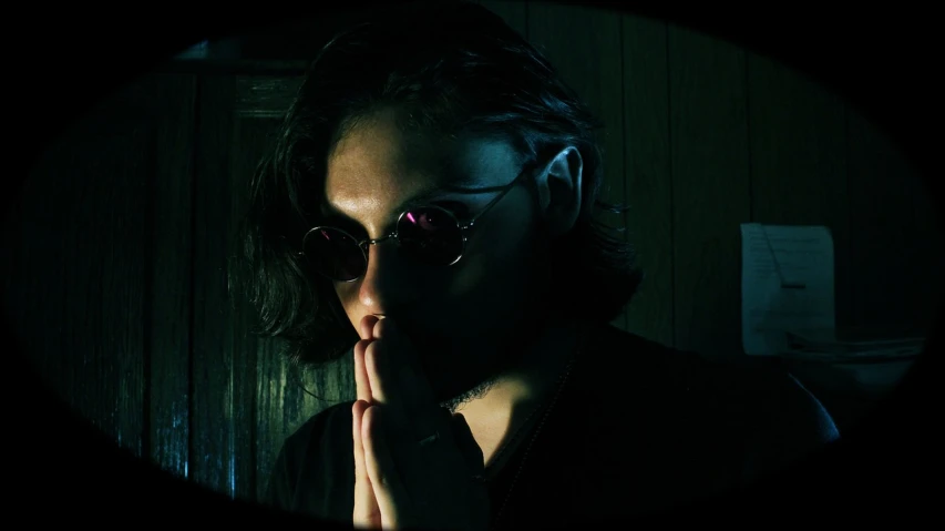 a close up of a person wearing sunglasses, inspired by Nan Goldin, flickr, neo-dada, praying, frank dillane, grungy gothic, full color still