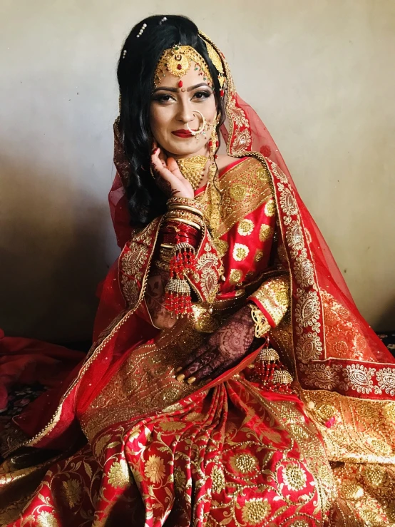 a woman in a red and gold dress posing for a picture, inspired by Saurabh Jethani, pexels, hurufiyya, bride, nepal, true realistic image, very detailed picture