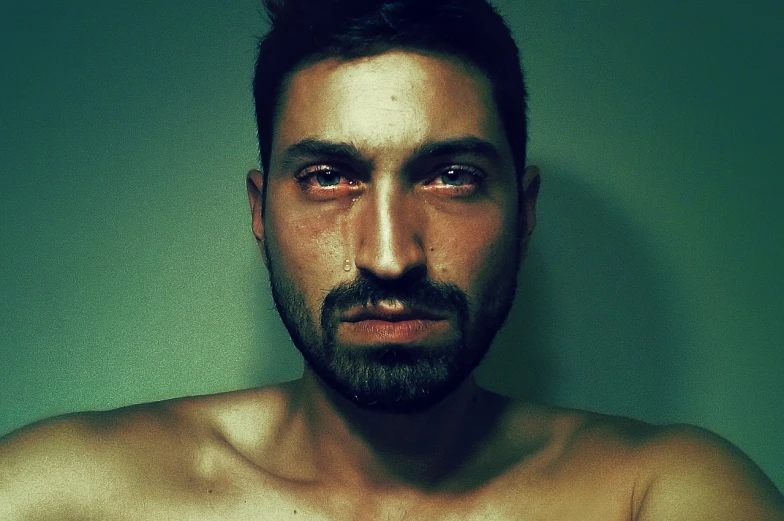 a close up of a shirtless man with a beard, a photo, by Andrei Kolkoutine, flickr, sad eyes tears, with instagram filters, with haunted eyes and dark hair, reza afshar