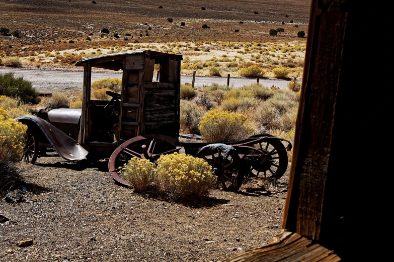 an old truck sitting in the middle of a desert, a photo, by Jeffrey Smith, flickr, entrance to 1900's mine, old furnitures, at high noon, a car