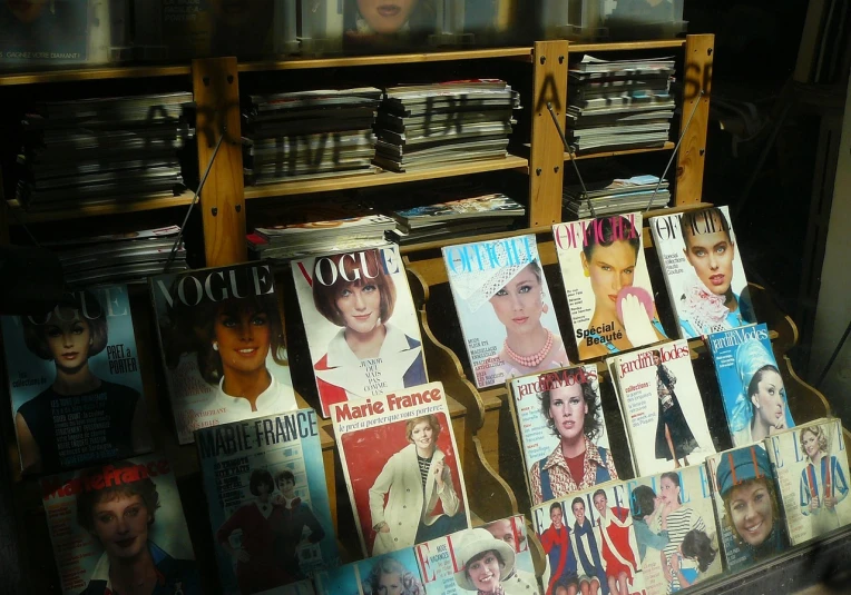 a bunch of magazines sitting on top of a shelf, by Douglas Shuler, flickr, art nouveau, perfect smile vogue, inside a french cafe, journalism, of mad men on madison avenue