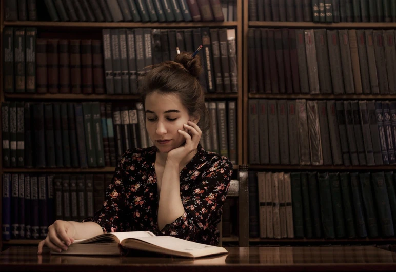 a woman sitting at a table in front of a book, a portrait, inspired by Elsa Bleda, pexels, romanticism, girl making a phone call, old library, portrait 4 / 3, stock photo