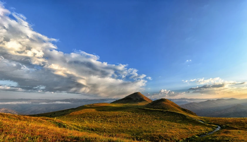 a grassy field with a mountain in the background, a tilt shift photo, by Muggur, flickr, les nabis, among heavenly sunlit clouds, jin shan, twins, last light on mountain top