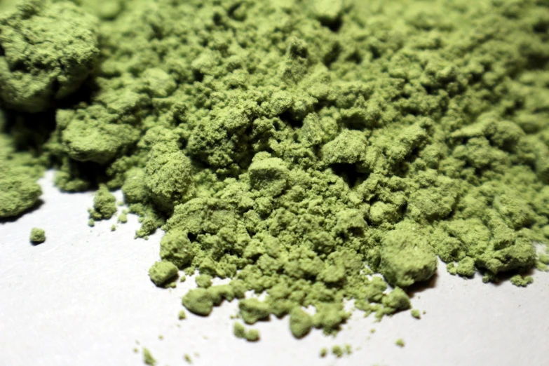 a pile of green powder sitting on top of a table, inspired by Masamitsu Ōta, flickr, ultrafine detail ”