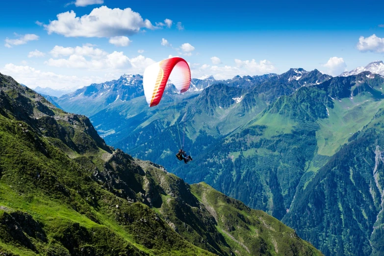 a person paragliding in the mountains on a sunny day, a stock photo, by Werner Andermatt, shutterstock, figuration libre, extraordinary colorful landscape, highly detailed saturated, switzerland, 8k photo
