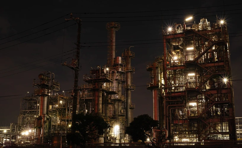 a large industrial plant lit up at night, by Tadashige Ono, flickr, photorealism, taken with sigma 2 0 mm f 1. 4, in neotokyo, david kassan, outdoor photo