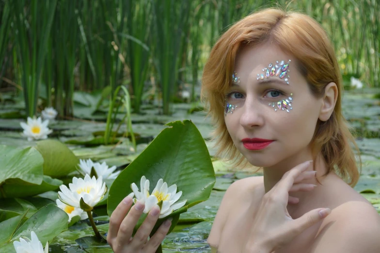 a woman with glitter on her face in a pond of water lillies, inspired by Frederick Carl Frieseke, shutterstock, ellie bamber fairy, swarovski crystals, white facepaint, cute photo