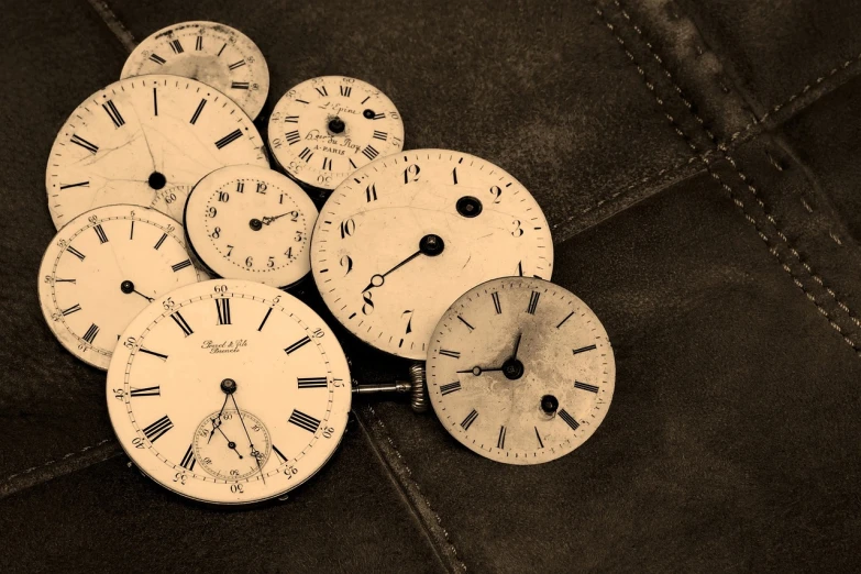 a bunch of clocks sitting on top of a piece of leather, a screenshot, by Andrei Kolkoutine, trending on pixabay, assemblage, sepia colors, flattened, black-and-white, age marks