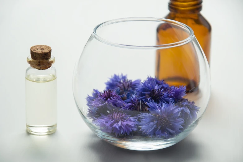 a glass vase filled with purple flowers next to a bottle of essential oil, crown of blue flowers, listing image, jars, thistle