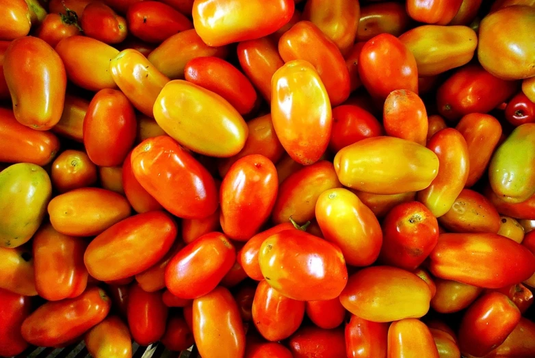 a pile of red and yellow tomatoes sitting on top of each other, a photo, very sharp photo, high res photo, jellybeans, 🦩🪐🐞👩🏻🦳