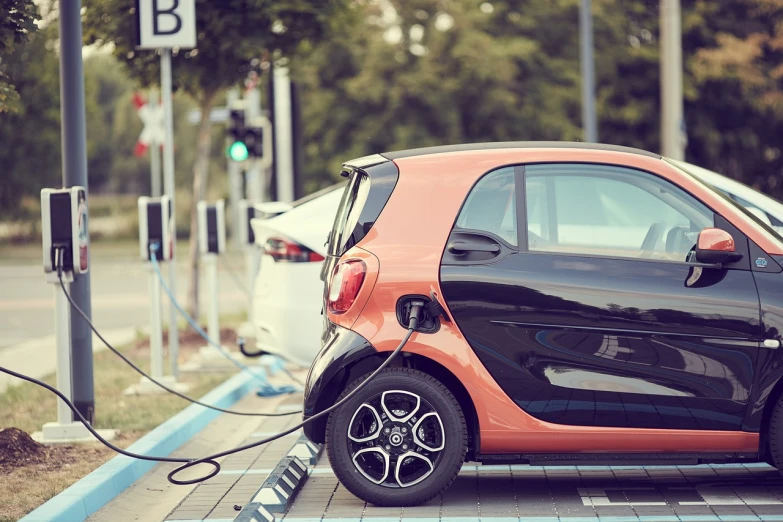 a smart car plugged into a charging station, shutterstock, les automatistes, 🦩🪐🐞👩🏻🦳, stylized photo, orange electricity, mooniq priem