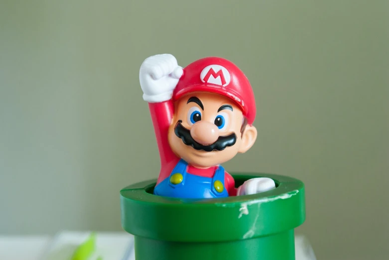 a close up of a toy on a table, inspired by Mario Comensoli, happening, hands up, growing, gaming toilet, hero