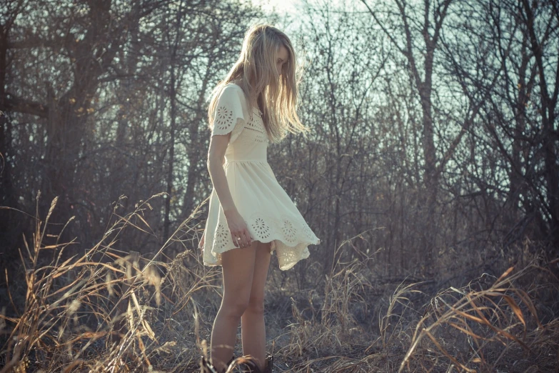 a woman standing in a field of tall grass, a picture, tumblr, romanticism, blond, soft shadow, nico wearing a white dress, winter sun