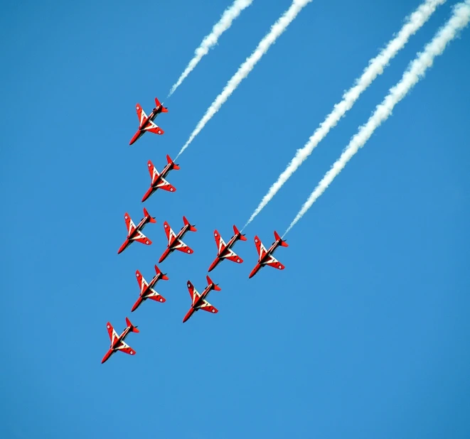 a group of jets flying through a blue sky, a photo, by Paul Bird, shutterstock, red velvet, brilliant symmetry, curved red arrow, breitling