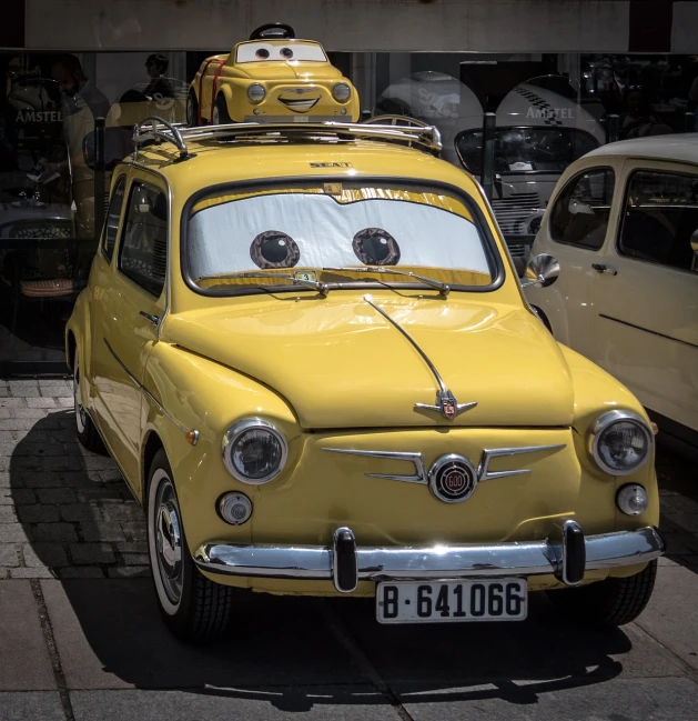 a yellow car is parked on the side of the street, by Samu Börtsök, flickr, big disney eyes, mozzarella everywhere, cute faces, kodakchrome : : 8 k