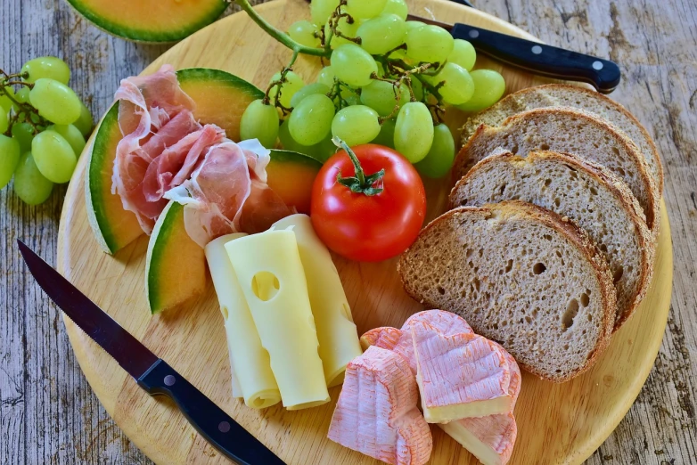 a close up of a plate of food on a table, pexels, cheese and salami on the table, bread, fruit, usa-sep 20