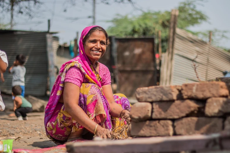 a woman sitting on top of a pile of bricks, a portrait, samikshavad, maintenance photo, smiling for the camera, surburb woman, very detailed picture