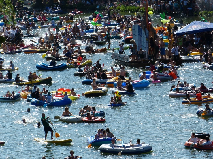 a large group of people floating down a river on inflatable rafts, by Dirk Crabeth, happening, parade, waldo in the top right of frame, high res photo, peacefully drinking river water