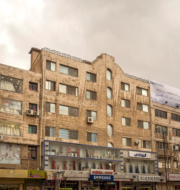 a very tall building with a lot of windows, by Ahmed Karahisari, flickr, old shops, on a cloudy day, al - qadim, medium wide front shot