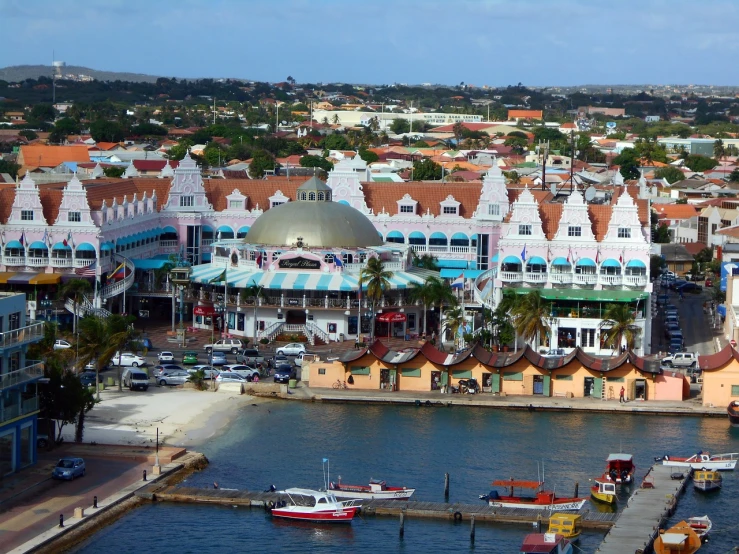 a number of boats in a body of water near buildings, a photo, aruba, red roofs, terminal, carousel