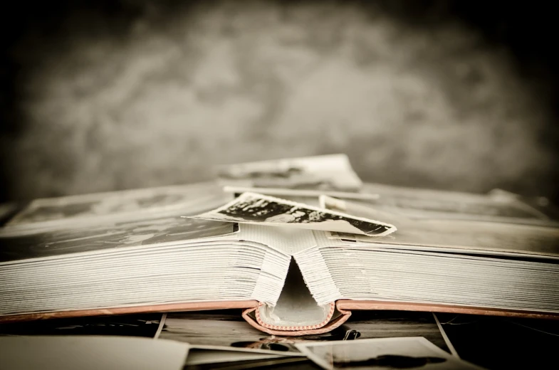 an open book sitting on top of a table, a picture, by Kurt Roesch, an extreme closeup shot, memories, lots of pictures, classified government archive