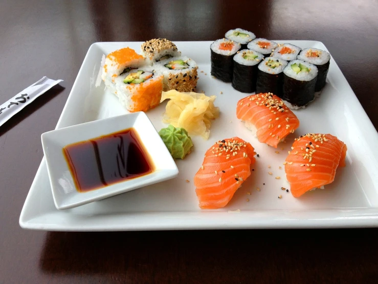 a white plate topped with different types of sushi, a picture, dau-al-set, lumi, salmon, marketing photo, chicago