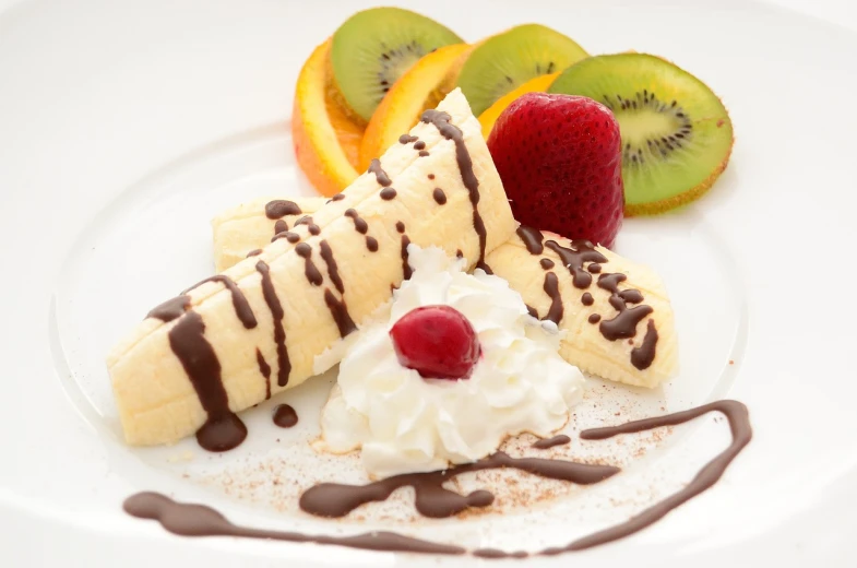 a white plate topped with fruit and whipped cream, flickr, chocolate sauce, banana, istockphoto, cone