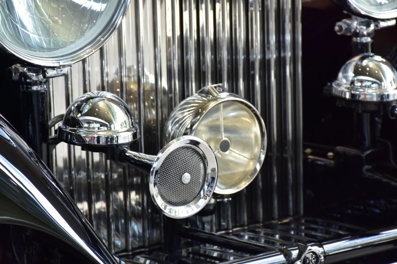 a close up of the front of a vintage car, an art deco sculpture, by Jay Hambidge, flickr, photorealism, speakers, silver filigree, interior light, side view close up of a gaunt