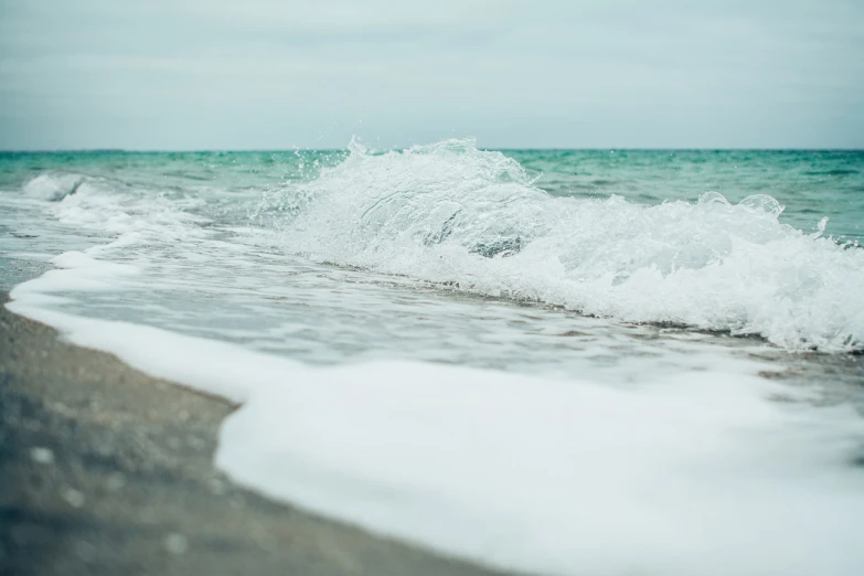 a person riding a surfboard on top of a wave, a picture, unsplash, minimalism, varadero beach, water particles, detailed wide shot, frozen sea