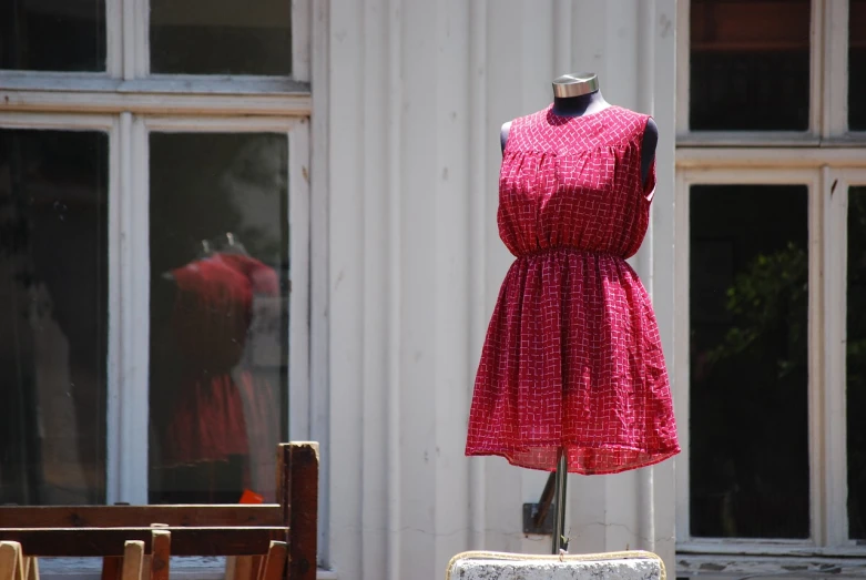 a dress on a mannequin in front of a window, flickr, red building, hot summer day, greek fabric, high res photo