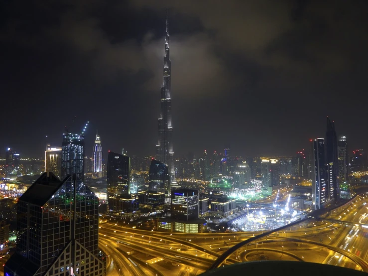 an aerial view of a city at night, a picture, hurufiyya, spire, view from ground level, very beautiful photo, dubai