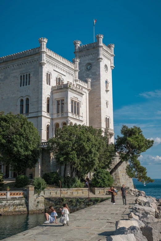 a large building sitting next to a body of water, inspired by Mihály Munkácsy, shutterstock, black sea, luxury castle, 3/4 view from below, watch photo