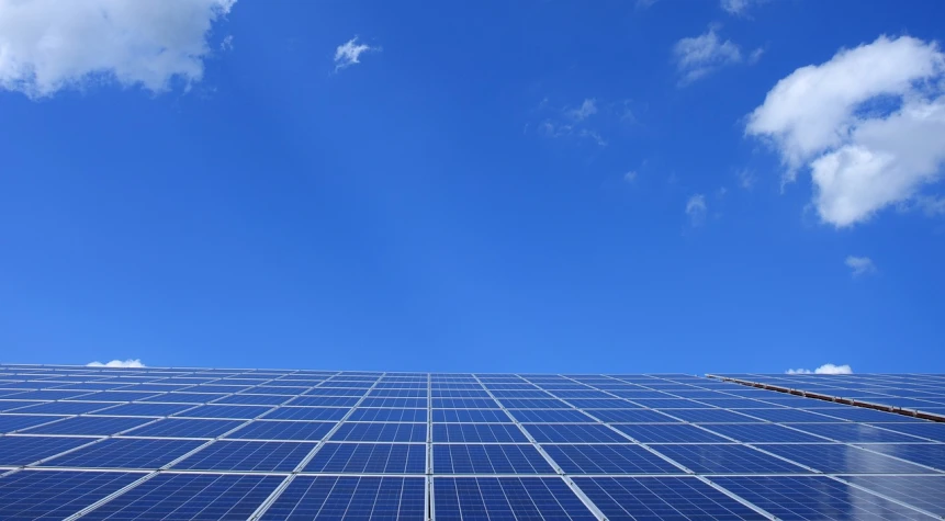 a building that has a lot of solar panels on it, by Carey Morris, pexels, bauhaus, view from below, with a blue background, wikimedia, solar power