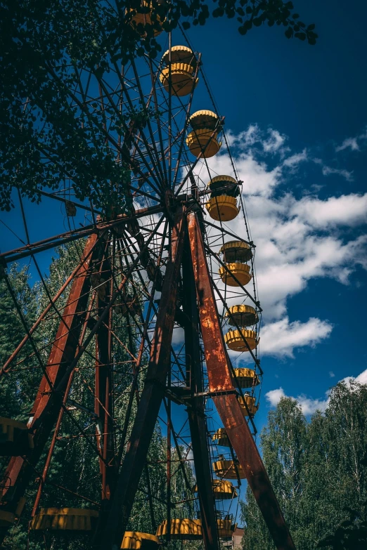 a ferris wheel sitting in the middle of a forest, a portrait, bauhaus, soviet town, with damaged rusty arms, sky blue, vostok-1