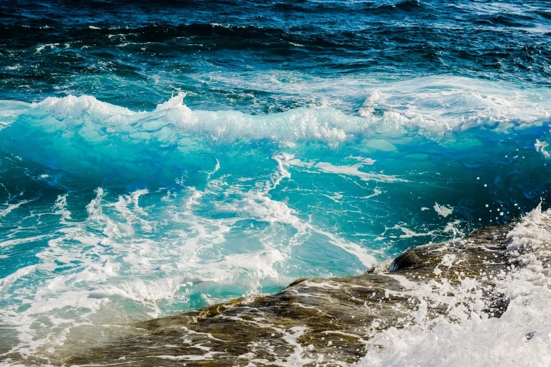 a man riding a wave on top of a surfboard, pexels, fine art, azure waves of water, rocky seashore, blue reflections, texturized