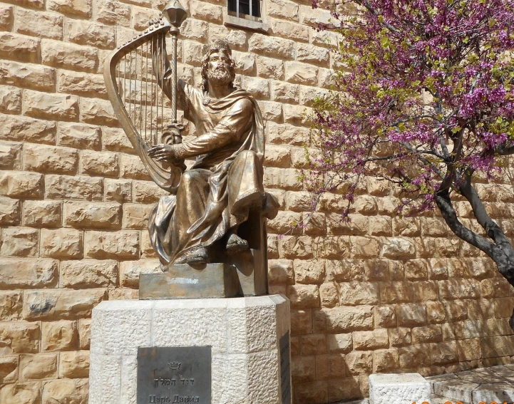 a statue of a man holding a harp in front of a building, by Saul Yaffie, dau-al-set, jesus of nazareth, not cropped, vista view, elias chatzoudis