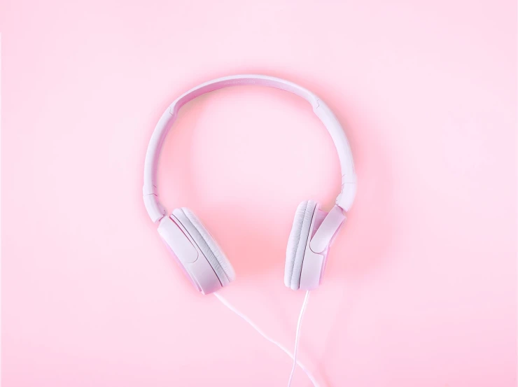 a pair of headphones sitting on top of a pink surface, a minimalist painting, trending on pexels, aestheticism, product introduction photo